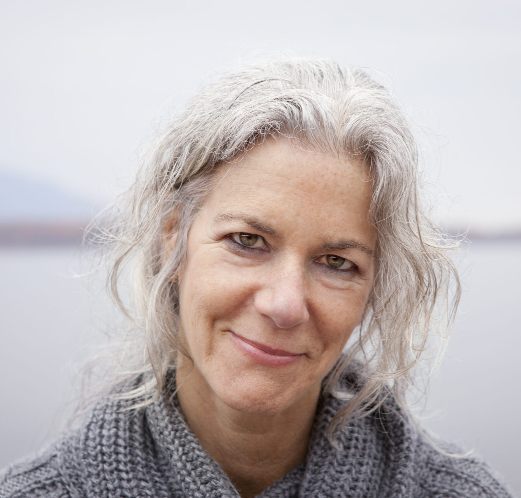 Ashokan, NY,U.S.,A woman looking at the camera, by the shore of a lake.